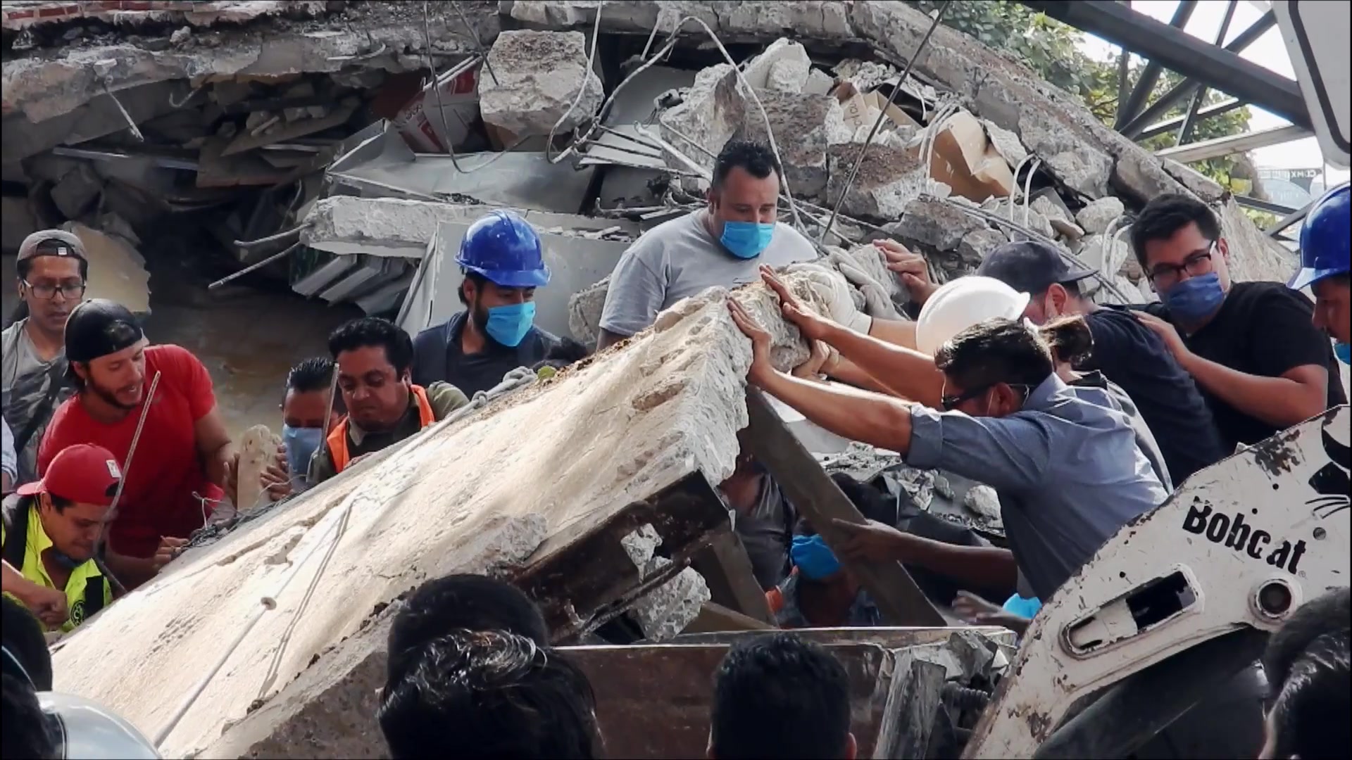 1985: Héroes entre ruinas, volunteers moving rubble together