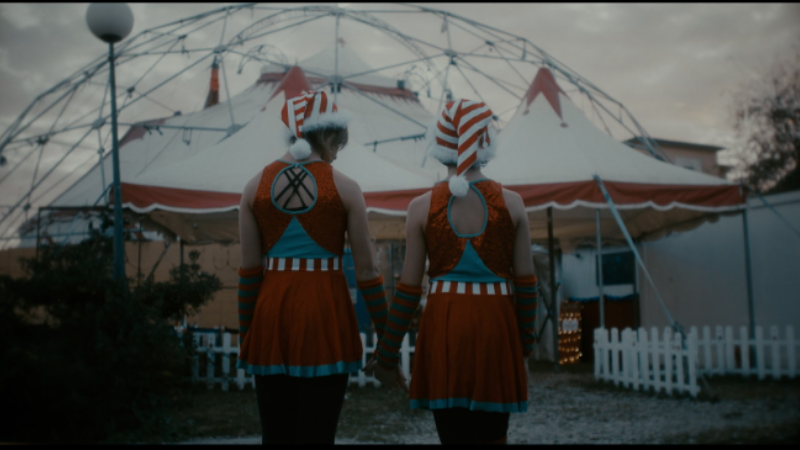 Circus performers in front of a big top in Cirk