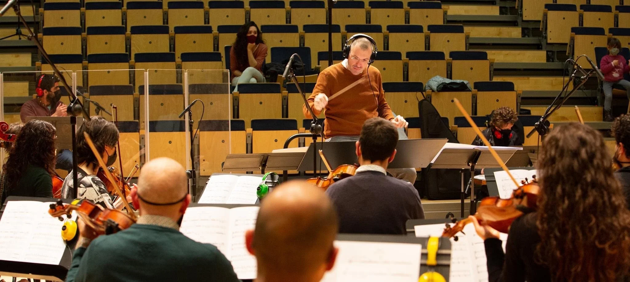 Gerard Pastor conducting the recording of the Sinjar soundtrack, with composer and singer Carolina Alabau in the background in the audience.