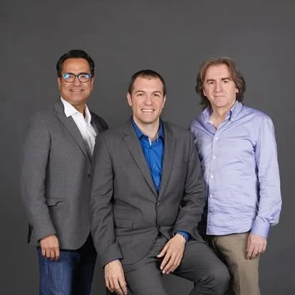 Josep Sanou, Diego Navarro and Gerard Pastor in suits posing and looking straight at the camera for a photo.